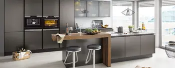 Moderne Designküche mit dunklen Fronten und Holztheke vor großen Fenstern.